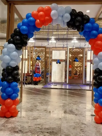A balloon archway entrance for a 'Cars' themed party, setting the tone right from the start with red, black, blue, and white balloons.