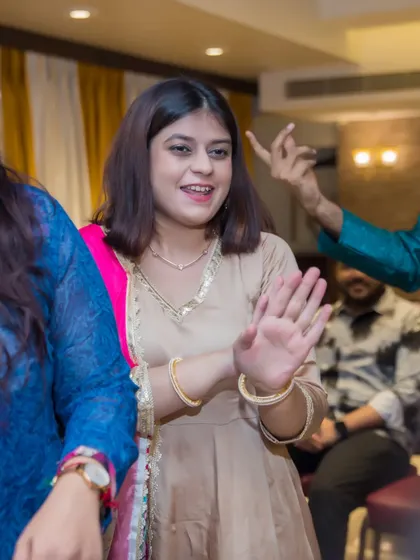 A guest enjoys the music and dancing at the Sangeet, her expression full of joy.