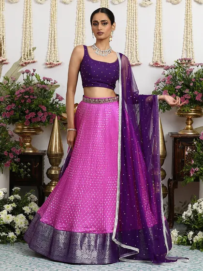The sleeveless purple blouse and pink Bandhani lehenga create a look of modern royalty, perfect for a sangeet or reception.