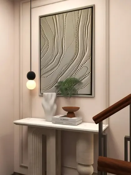 A sculpted stone console table and abstract art create an elegant vignette by the staircase in the Hemkunt residence.