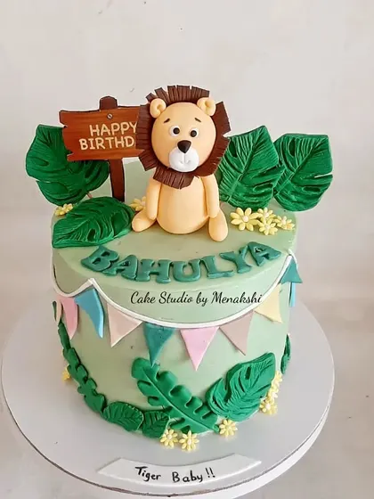 A beautiful jungle themed cake with a friendly lion on top. I used shades of green and handcrafted leaves to create a lush, wild setting for this birthday celebration.