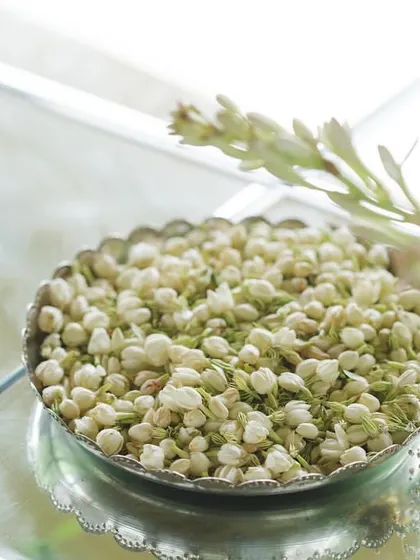 A bowl of fresh jasmine buds, used for both fragrance and as a beautiful, traditional decor element.