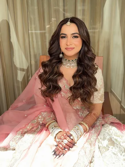 Soft glam and open hair are a match made in heaven. This stunning bridal look in pastel pink features glowing skin and delicate makeup.