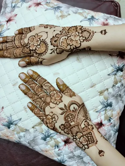 This is an example of an asymmetrical design, where each hand has a different but complementary pattern. It's a modern and stylish take on traditional henna.