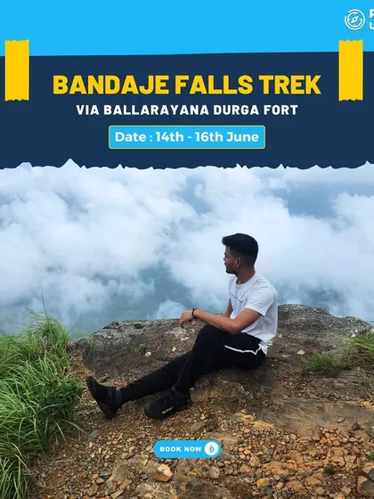 A solo trekker sits on a cliff edge, gazing at the clouds below on the Bandaje Falls trek.