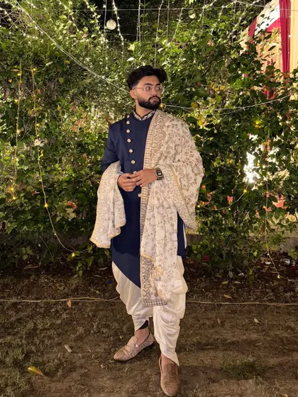 A client looking sharp in our navy blue Indo-Western set with a printed dushala. This is a great rental option for a sangeet or reception, offering a modern yet traditional vibe.
