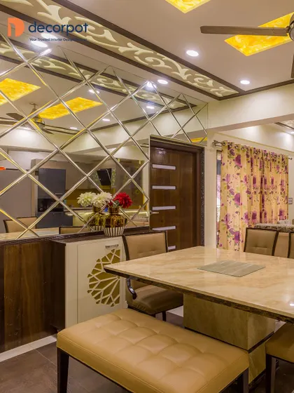 A close-up of the dining area, highlighting the mirrored wall and custom crockery unit that adds depth and a sense of luxury to the space.