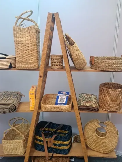 This display from one of our exhibitions showcases the variety of our handcrafted bags and baskets. It demonstrates the range of shapes, sizes, and materials we work with, from seagrass totes to woven storage baskets.