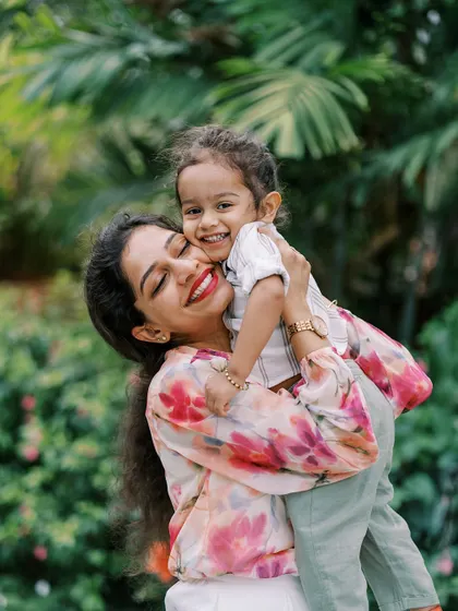 A mother hugging her son. The genuine emotion and her bright smile make this a heartwarming photo.