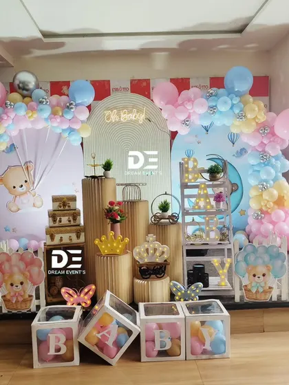 A chic and modern 'Oh Baby' shower with a teddy bear theme. The setup features pastel pink and blue balloon arches against a clean, contemporary backdrop.