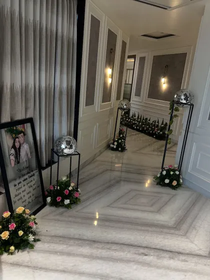 Even the most intimate celebrations deserve grand details. We transformed this home's hallway for a pre-wedding function with elegant floral arrangements, personalized welcome signs, and subtle touches like disco balls for a hint of glamour.