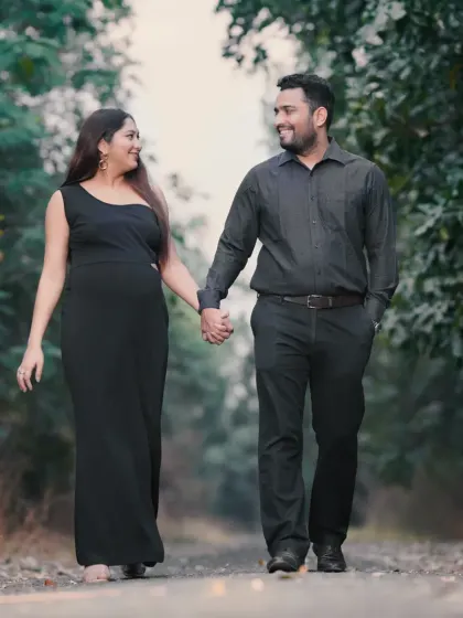 A candid moment of a couple walking hand-in-hand through a tree-lined path. Outdoor sessions allow for natural movement and interaction, resulting in relaxed and authentic photos.