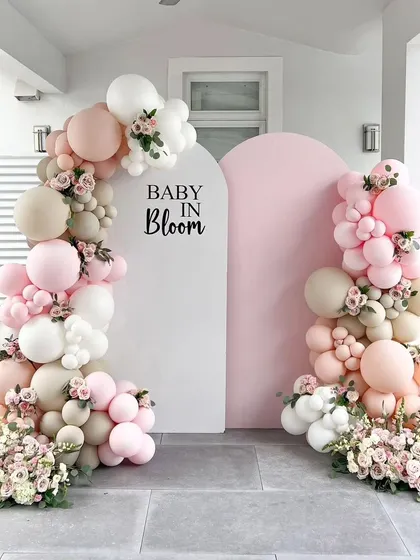 A "Baby in Bloom" setup at the entrance of a home. The pink and white balloon arches create a beautiful and welcoming frame for guests as they arrive.