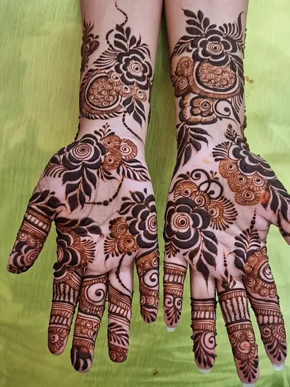 This design features scattered floral motifs connected by thin, leafy vines. The open space on the palm makes the individual flowers stand out.
