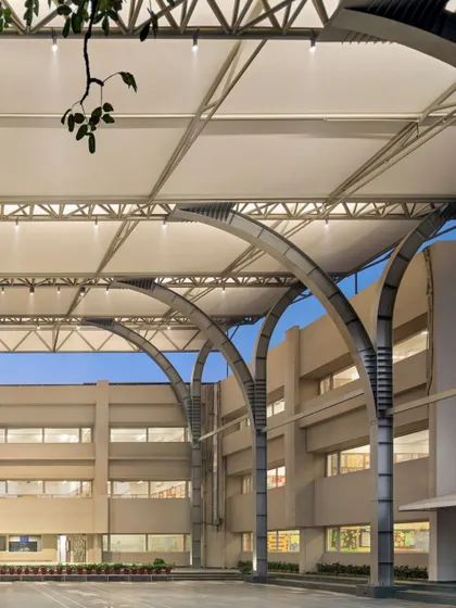 The series of prefabricated steel trusses and arches supports the 30-meter clear span canopy. This structural system is not only efficient but also creates an elegant, rhythmic pattern against the sky, enhancing the architectural character of the courtyard.