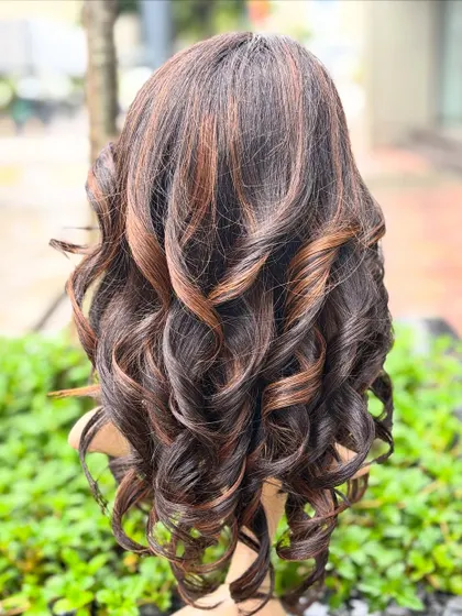 The back view of our molten honey wig, showing off the glamorous, everyday-wearable custom color and soft curls.