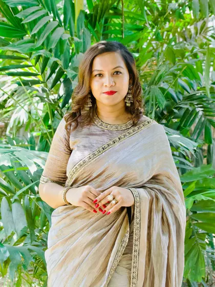 A client looking elegant in a beige tissue silk saree with a detailed border.