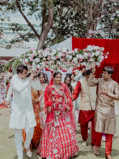 A beautiful bridal entry with her family holding a stunning floral canopy. We capture the grandeur and emotion of this special walk.