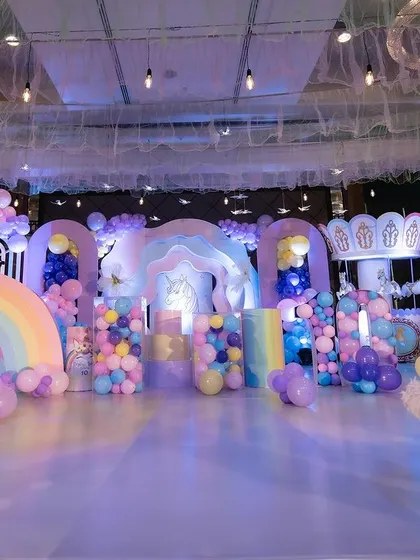 The complete magical unicorn birthday party stage. I used pastel colors, rainbow props, carousel unicorns, and a dreamy ceiling with hanging lights and birds to create an enchanting world.