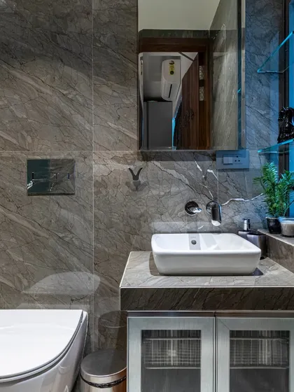 This bathroom in the Filigree House uses dark grey marble tiles to create a moody and sophisticated atmosphere. The clean lines of the fixtures and the floating vanity keep the space feeling modern and uncluttered.