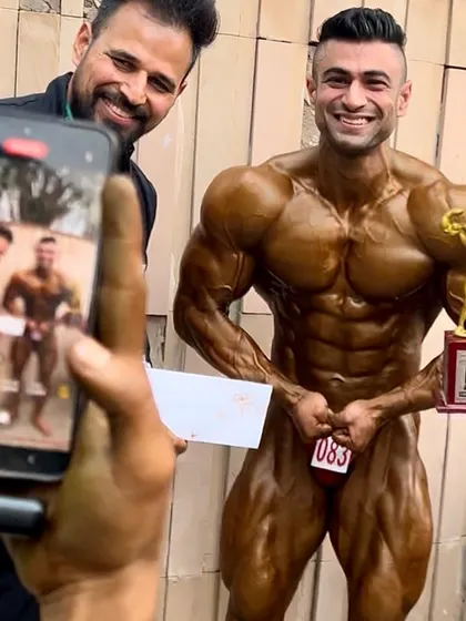 Capturing the winning moment. My athlete with his trophy, showcasing the physique that brought home the victory.