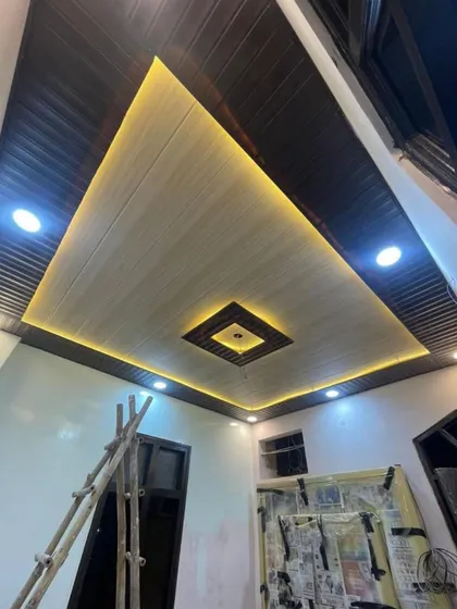 Wooden texture waale is design mein humne centre mein ek square element aur kinaron par cove lighting di hai.