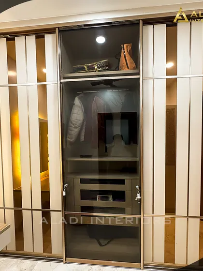 A close-up of a sliding wardrobe with a combination of frosted and clear glass panels, offering a glimpse of the organized interior.