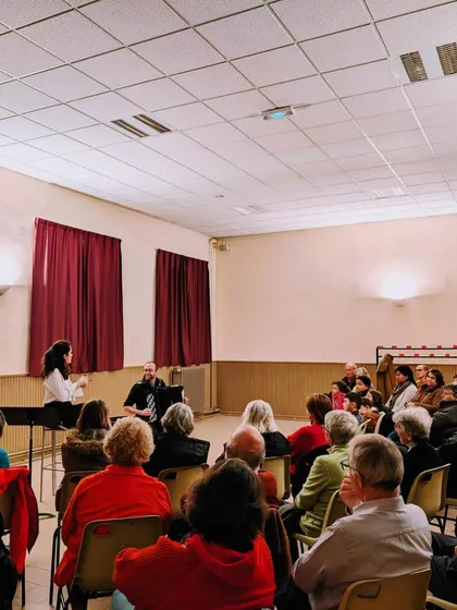 A wide shot of our 'Little Italy' concert, showing the audience gathered in a local venue in France. We are committed to bringing our performances to diverse communities, both large and small.