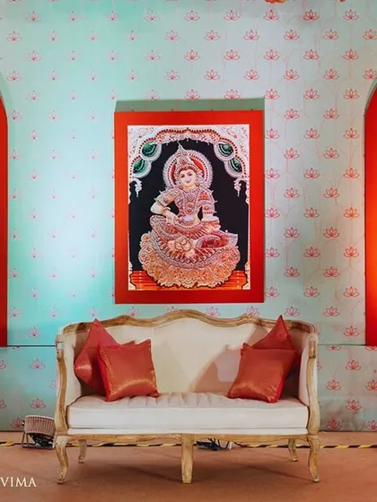 The stage for this half-saree function featured a backdrop with beautiful traditional paintings. These artworks depict the stages of a woman's life, adding a rich narrative layer to the celebration.