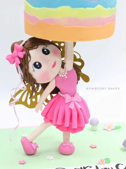 A close-up of the hand-sculpted fondant girl figurine, the central element of my gravity-defying cake. Her pose and expression are key to the cake's story.