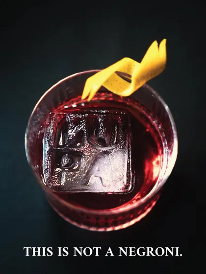 A classic-looking dark red cocktail with a custom Lupa ice cube, captioned "This is not a negroni." This final teaser played with expectations just before we revealed our special menu.