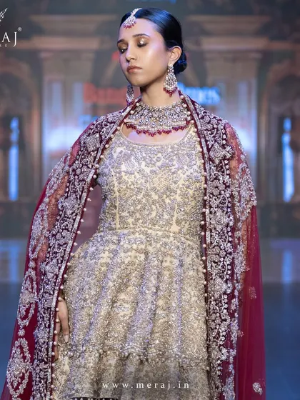 A stunning Gold and Maroon Indo-Western ensemble, featuring a velvet tail lehenga and a net double-layer peplum top, perfect for wedding celebrations.