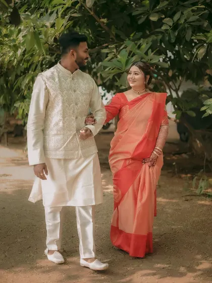 A classic walking shot of the couple, arm-in-arm, looking happy and relaxed on their special day.