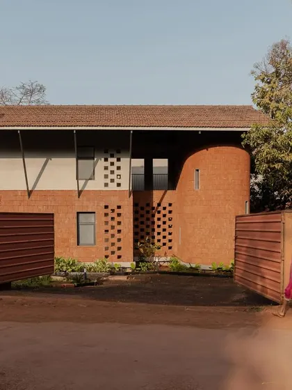 The entrance gate of Maison Rouge, opening to reveal the vernacular-inspired architecture within.