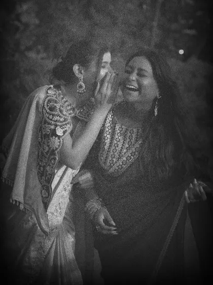 A candid black and white shot capturing a moment of shared laughter, evoking the feel of a classic 1950s film.