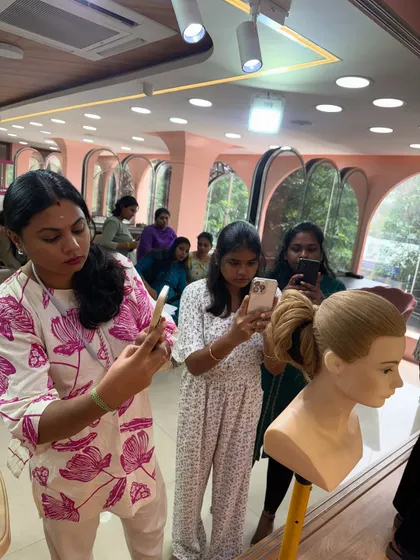 Students capturing every angle of a finished hairstyle to study the structure and details.