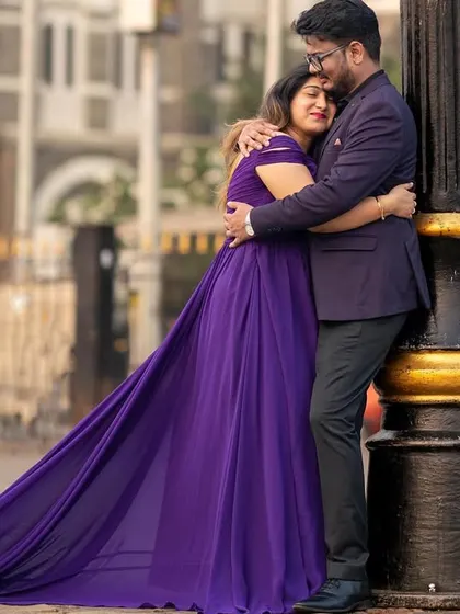 A tender embrace on a city street. The long trail of the purple gown adds a touch of elegance and drama, transforming a simple moment into something magical.