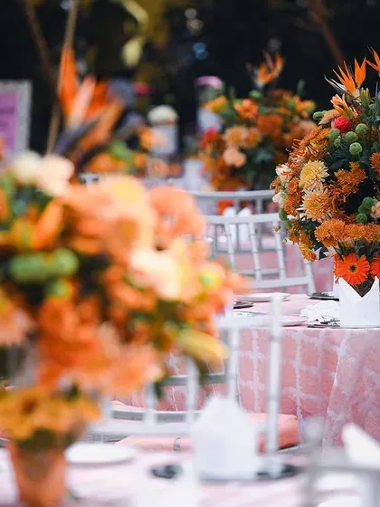 The dining tables at the garden Mehendi were adorned with lush floral centerpieces in shades of peach and orange. The soft pink linens complemented the Pantone 'Peach Fuzz' theme perfectly.