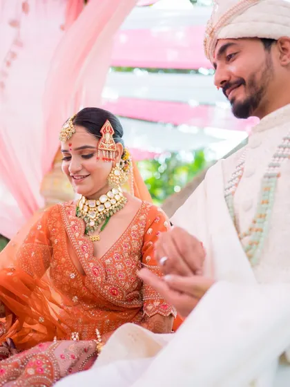 A candid moment from the wedding ceremony. The bride's makeup looks flawless and beautiful as she shares a moment with her groom.