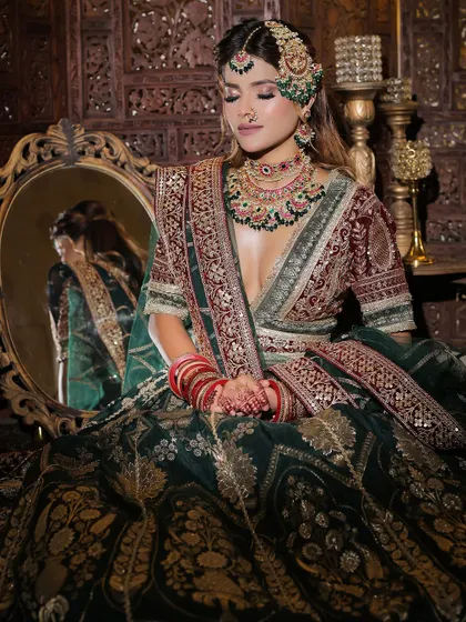 A close-up of the bride, highlighting the flawless makeup and the heavy bridal jewellery that completes the look.
