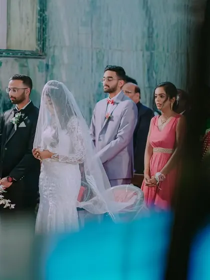 A wide shot of the couple standing at the altar during the church ceremony, a moment of solemn vows and blessings.