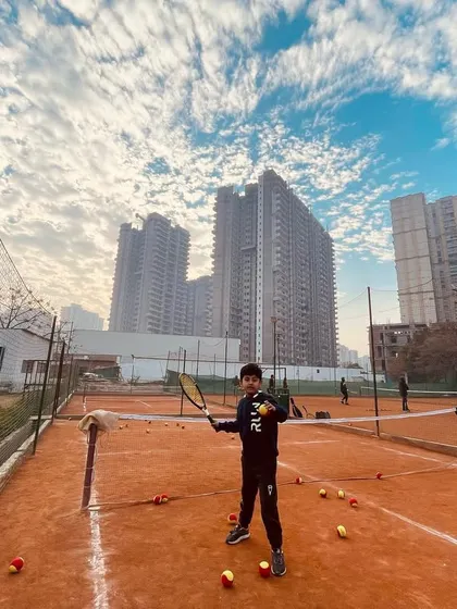 A young player ready for action on the mini-tennis court.