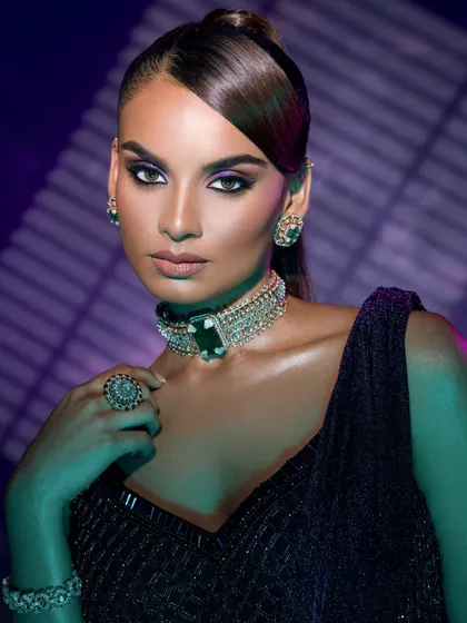A close-up using colored gels to create a moody, artistic effect, focusing on the model's expression and the striking jewelry.