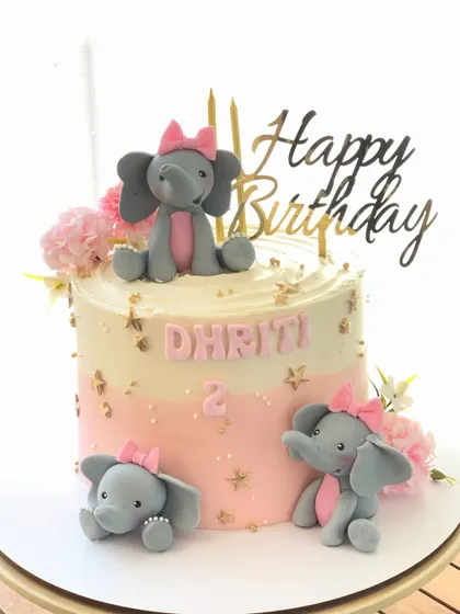 An adorable elephant-themed cake for a second birthday, with a pink and gold color scheme.