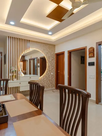 A stunning dining area featuring a large wooden table, a floating vanity with a backlit circular mirror, and elegant wall paneling. This space is designed for memorable meals with family and friends.