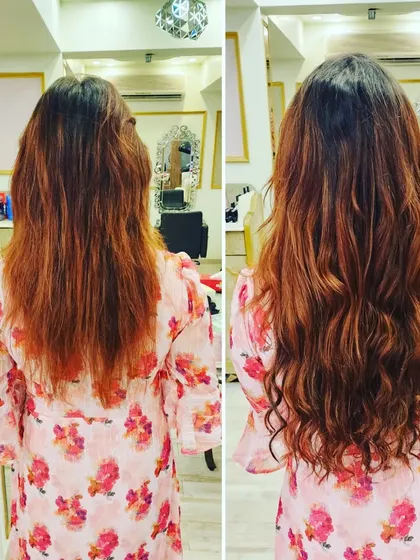 This client's hair was given a boost with wavy extensions that complement her existing color, resulting in a fuller, more vibrant style.