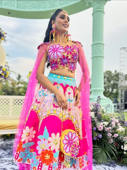 The full look, showing how the high ponytail complements the vibrant and unique lehenga.