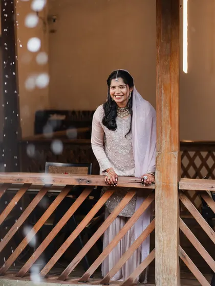 A beautiful portrait of the bride on a wooden balcony, her happy expression lighting up the frame.