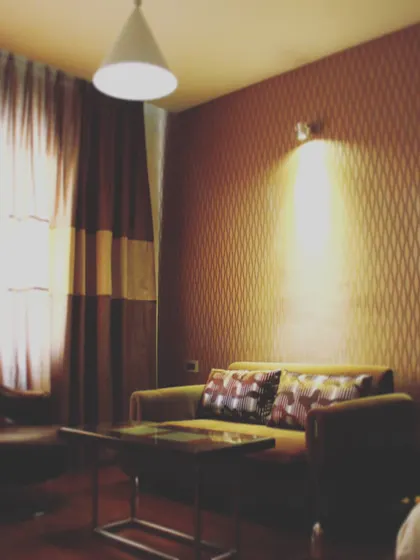 A cozy seating area within a hotel room in Hospet. We used warm, directional lighting and textured wallpaper to create an intimate and inviting atmosphere for guests to relax in.