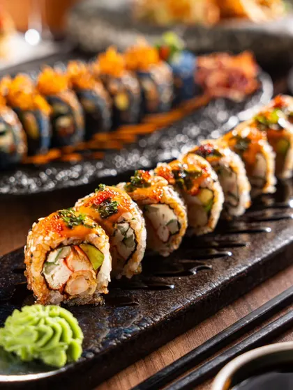 A detailed close-up of a beautifully plated sushi roll, focusing on the textures and colors of the toppings. This highlights the artistry of the dish.